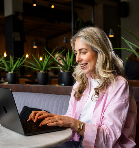 Persoon werkt op laptop in een caf&eacute;omgeving