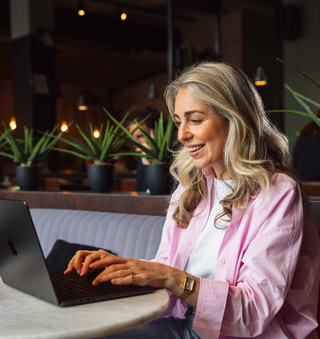 Persoon gebruikt laptop aan cafétafel