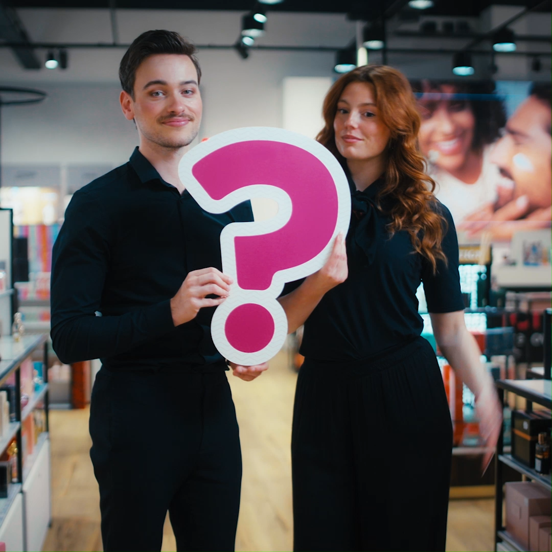 Twee personen met vraagtekenbord in een winkel