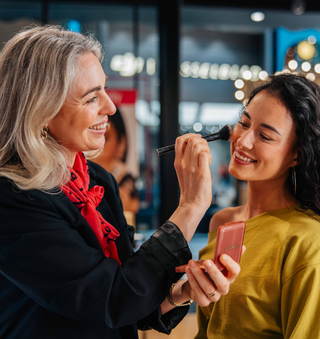 Twee vrouwen in gesprek bij parfumwinkel