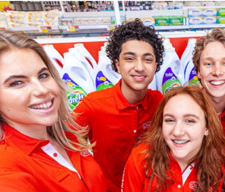 Medewerkers van Kruidvat in de winkel lachen samen